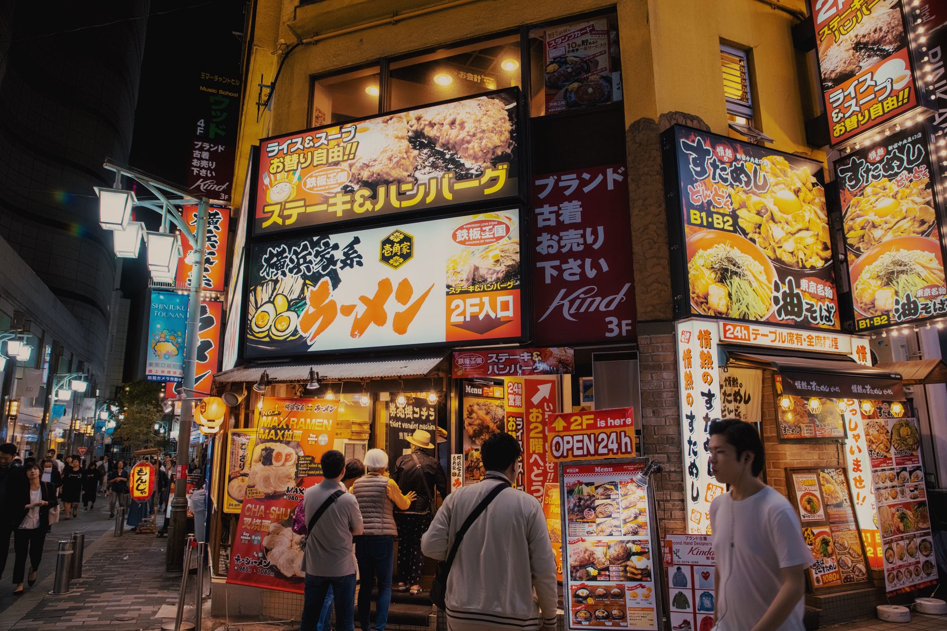 Tokyo street lined with lit restaurant signs at night