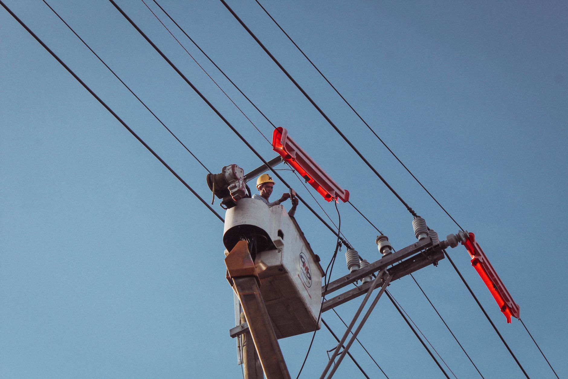 Electrician in a lift working on overhead power lines