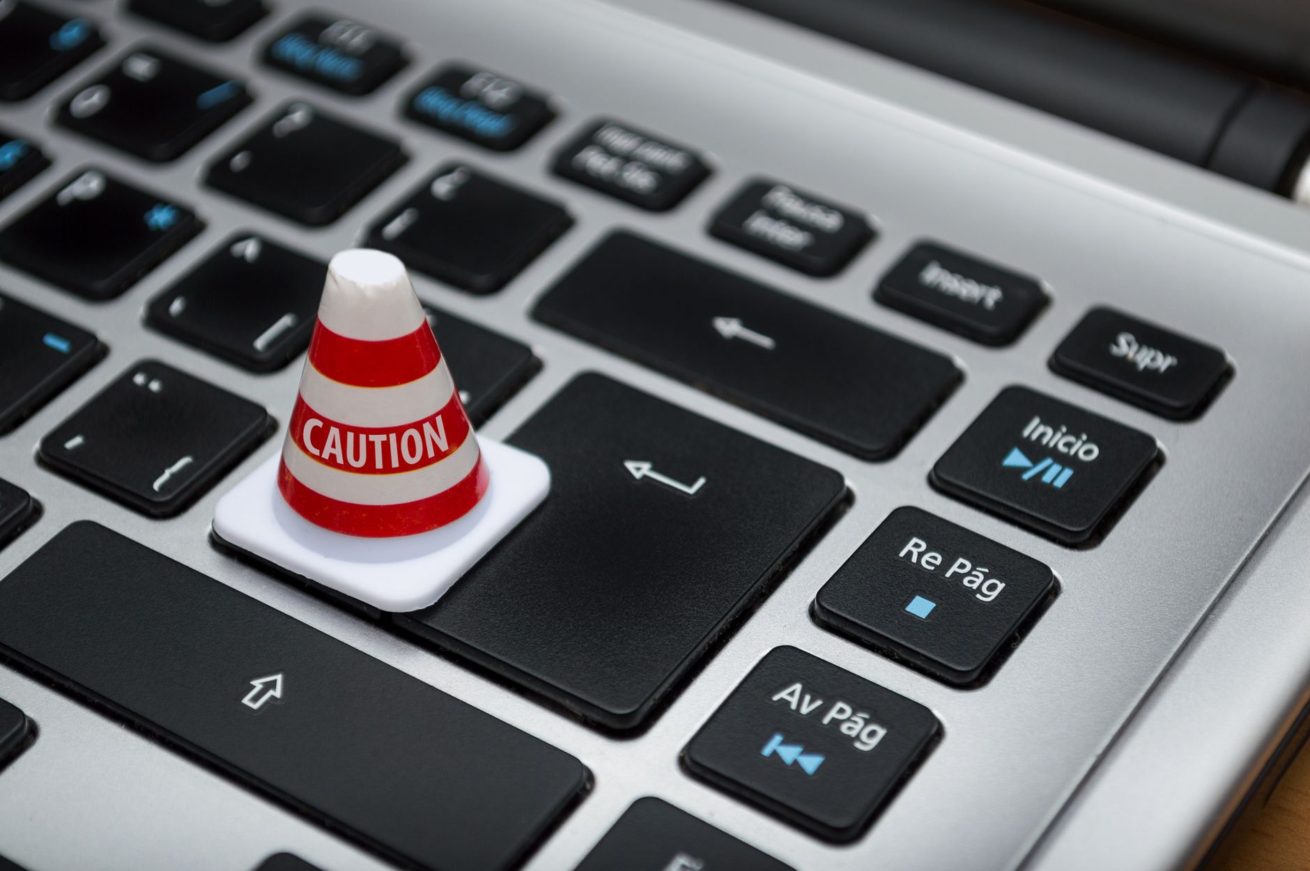 Miniature caution cone sitting on a laptop keyboard