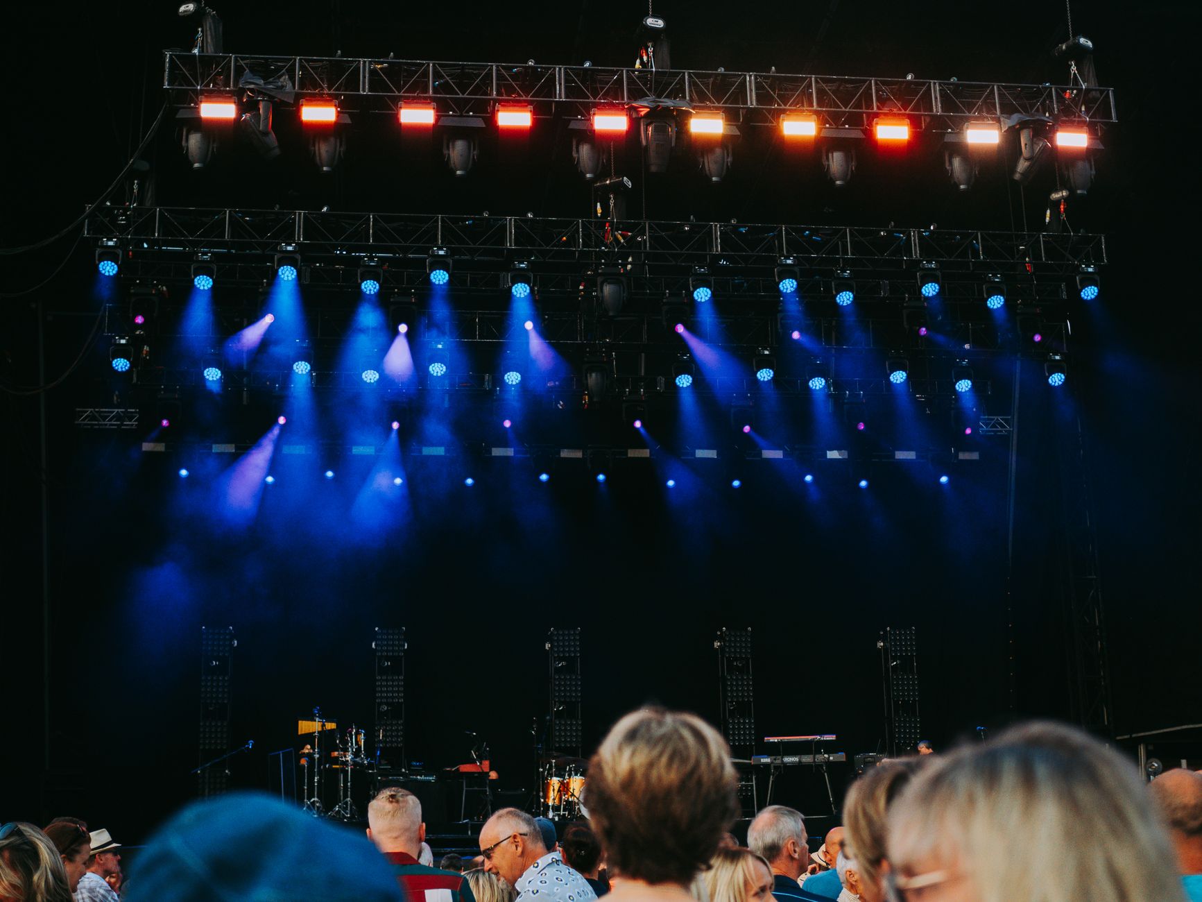 Concert audience in front of a stage with colorful lights