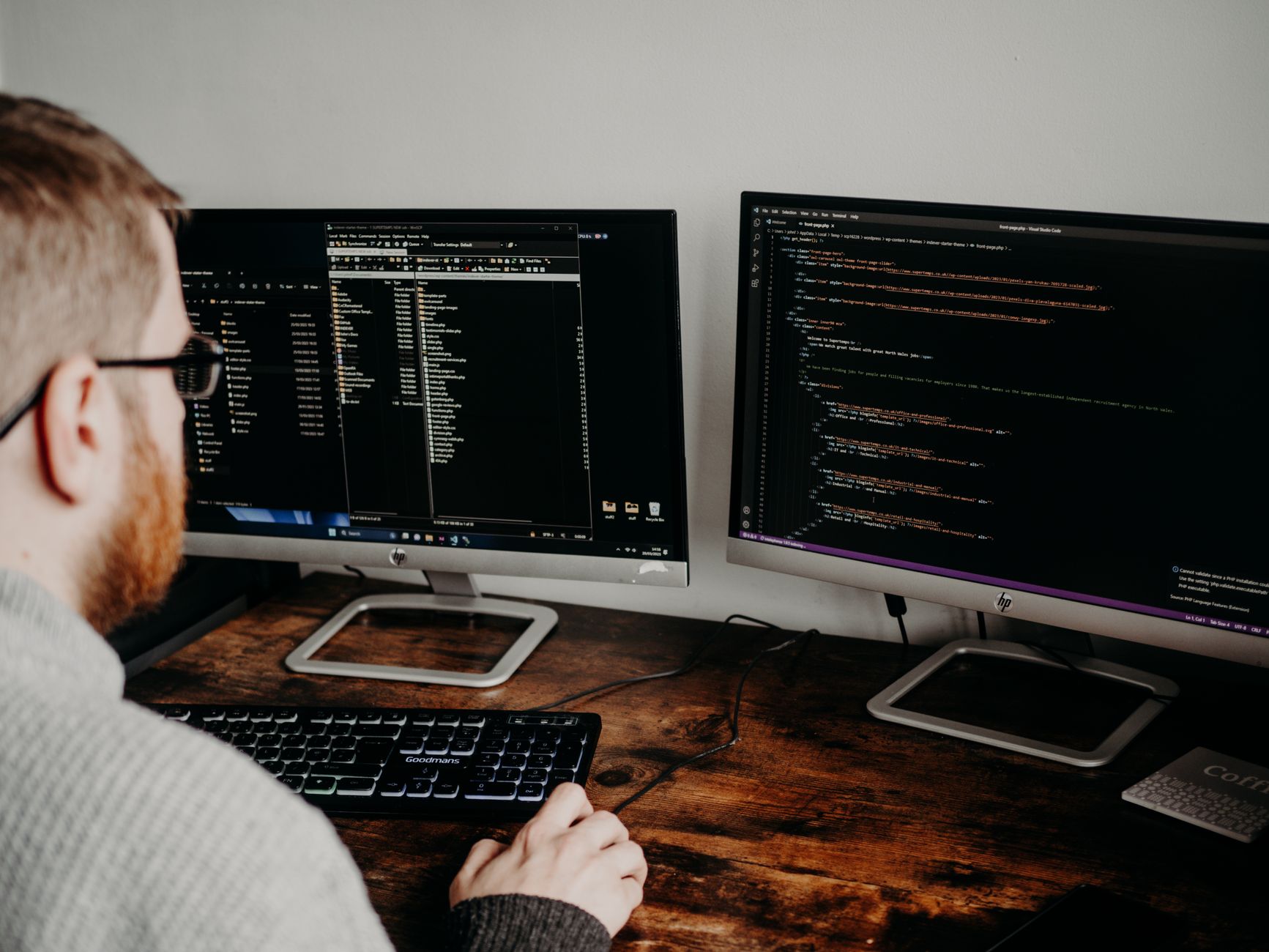Developer working on code across two monitors