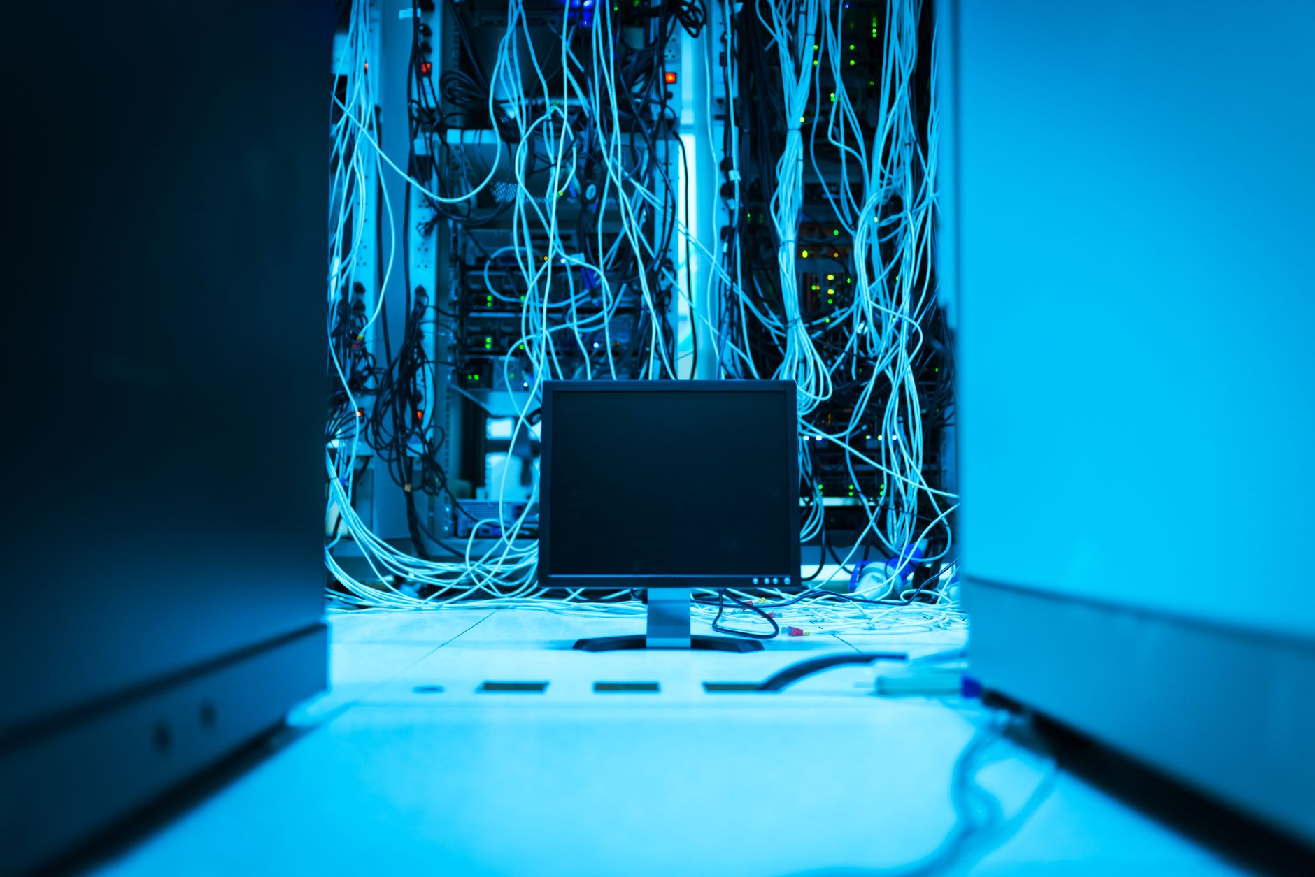 Server room cabling with a monitor in blue light