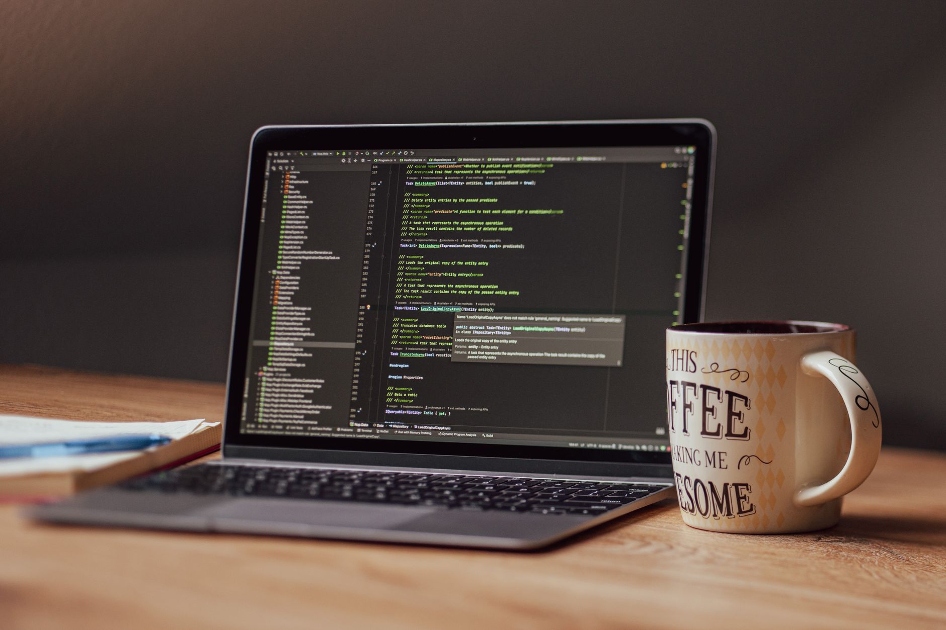 Laptop showing a code editor next to a coffee mug